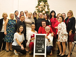 Image of all ladies together in the front of the Christmas tree